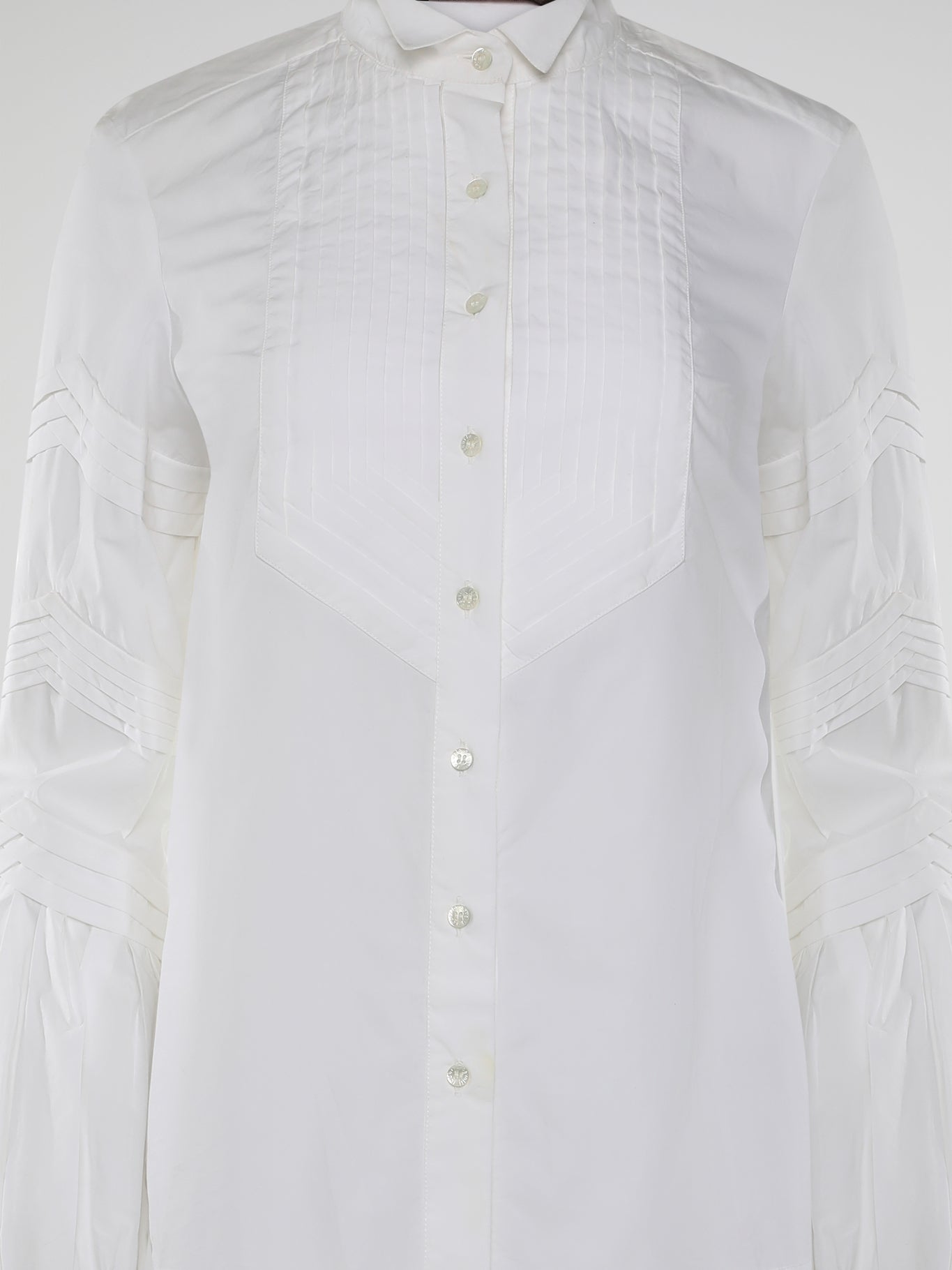 Step into the world of timeless elegance with the White Pleated Bib Shirt from Roberto Cavalli. Crafted with meticulous attention to detail, this masterpiece combines effortless sophistication with a touch of whimsical charm. From its delicate pleated bib to its crisp white fabric, this shirt will make a statement in any setting, exuding refined elegance that is truly captivating.