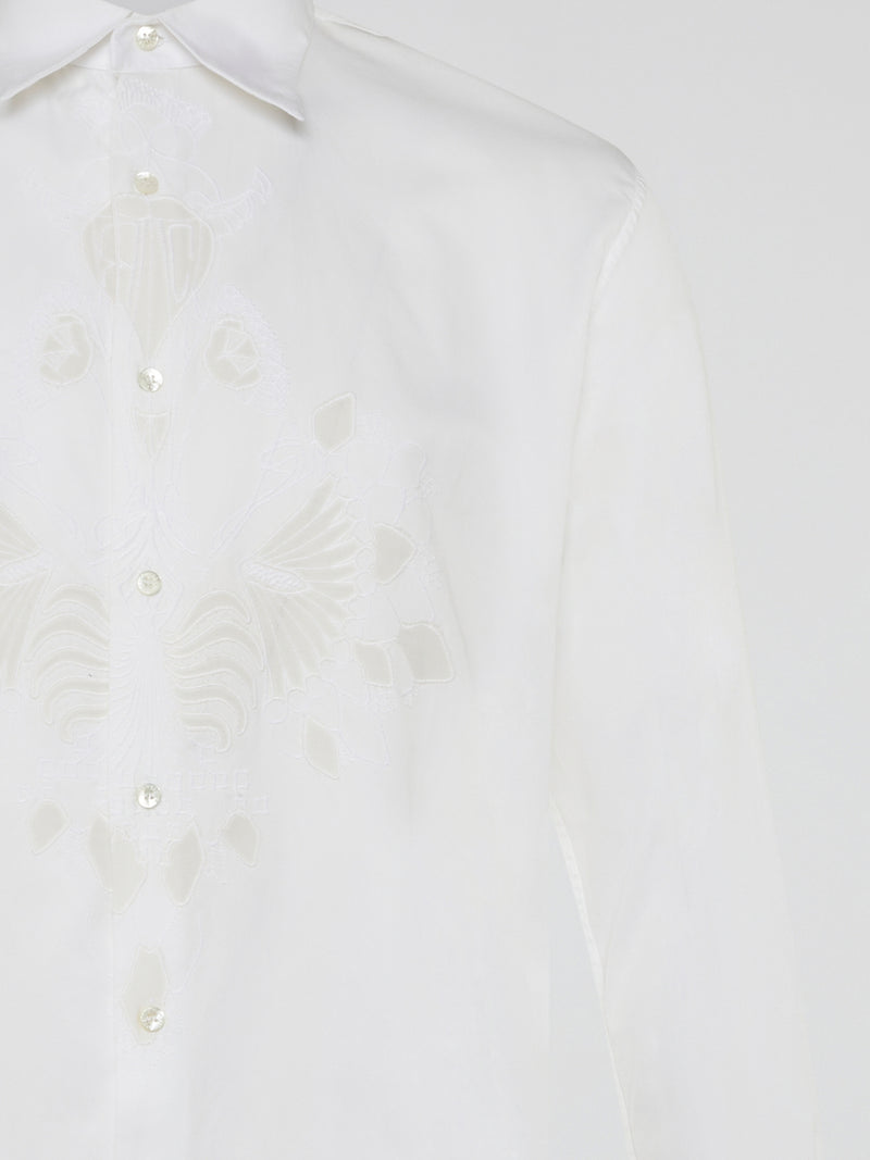 Step into a realm of elegance with the White Embroidered Shirt by Roberto Cavalli, where classic sophistication meets modern charm. Crafted with meticulous attention to detail, this shirt showcases exquisite floral embroidery that dances gracefully across the pristine white fabric. Embrace your inner fashion icon as you effortlessly blend timeless style with a touch of Italian flair, making a statement that is as timeless as it is enchanting.